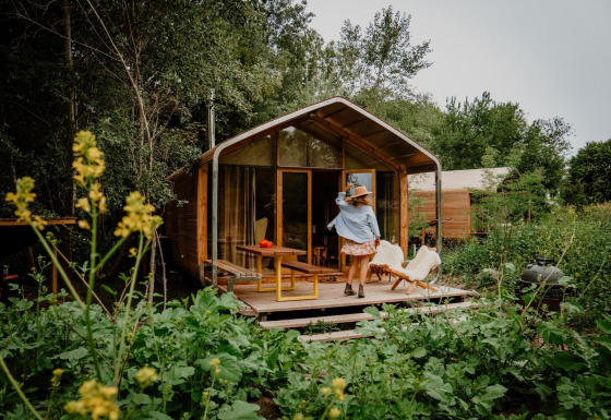De mooiste hut ter wereld bij Les Cabanes d'Ostende in België, met weelderig groen en veldbloemen.