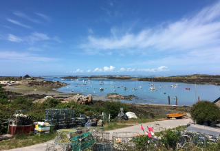 Udsigt over både i bugten ved Camping O2 i Normandiet, Frankrig, med garnfælder og blå himmel.