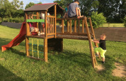 Children play on a playground with a slide and climbing frame at Camping O2 holiday park in Normandy, France.