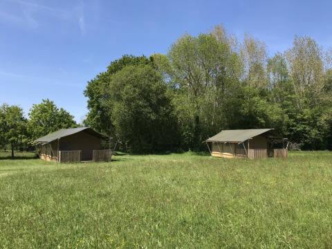 Due tende safari su un prato verde al Camping O2, parco vacanze in Normandia, Francia, con cielo sereno.