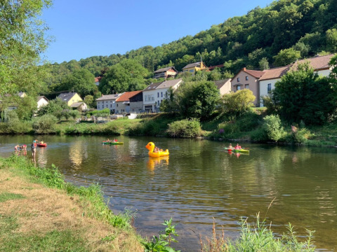 Folk nyder kanoer og en oppustelig and på en flod ved Camping du Rivage i Diekirch, Luxembourg.