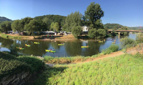 Vista panoramica del fiume con kayak e paesaggio verde al Camping du Rivage, Diekirch, Lussemburgo.