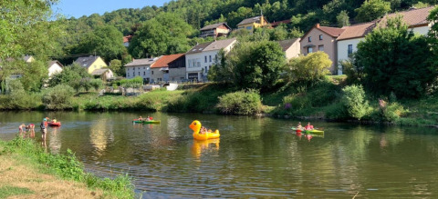 Persone che remano e si rilassano su canoe e un grande gonfiabile ad anatra a Camping du Rivage, Diekirch.