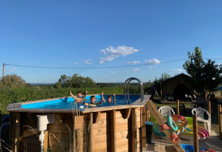 Bambini che giocano in una piscina fuori terra al Minicamping Sous les Cloches, Auvergne-Rhône-Alpes, Francia.