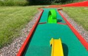 Minigolfbane ved Camping Yttermalungs i Dalarna, Sverige med kunstgræs, farverige forhindringer og solrigt vejr.