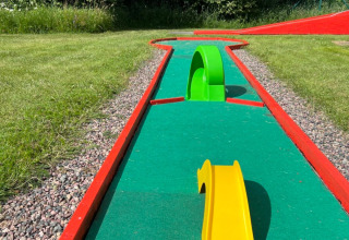 Minigolfbane ved Camping Yttermalungs i Dalarna, Sverige med kunstgræs, farverige forhindringer og solrigt vejr.