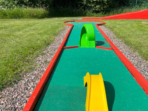Minigolfbahn im Camping Yttermalungs, Dalarna, Schweden, mit bunten Hindernissen und grünem Rasen.