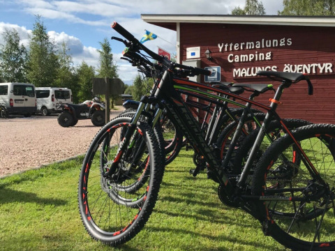 Biciclette da montagna parcheggiate sull’erba al Camping Yttermalungs, parco vacanze in Dalarna, Svezia.