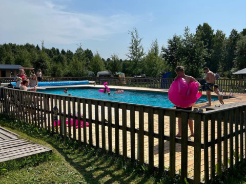 People enjoying a sunny day at the pool in Camping Yttermalungs holiday park, Dalarna, Sweden.