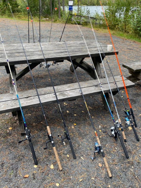Canne da pesca disposte vicino a un tavolo da picnic al Camping Yttermalungs in Dalarna, Svezia.