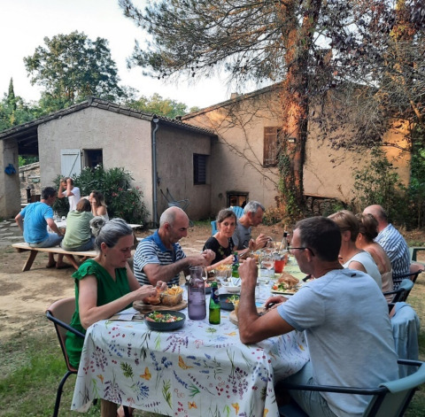 Cena al aire libre en Domaine La Sauzette, parque vacacional en Occitanie, Francia, con huéspedes compartiendo.