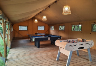 Sala de juegos en tienda en Domaine La Sauzette, Occitanie, Francia, con futbolín, billar y ping pong.
