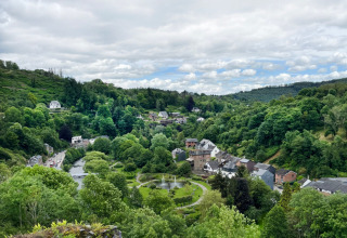 Panoramablick auf grüne Hügel, Fluss, Häuser und Bäume im Ferienpark Camping la Roche, Limburg, Belgien.