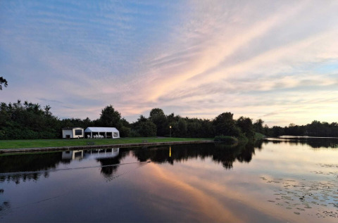 Idyllische Uferszene im Camping de Kleine Wielen, Friesland, Niederlande, bei Sonnenuntergang am See.