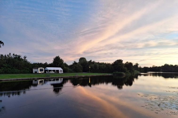 Peaceful lakeside view at Camping de Kleine Wielen holiday park in Friesland, Netherlands, at sunset.
