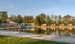 Vista de parque de vacaciones con tobogán de agua y cabañas en Camping de Kleine Wielen, Frisia, Países Bajos.