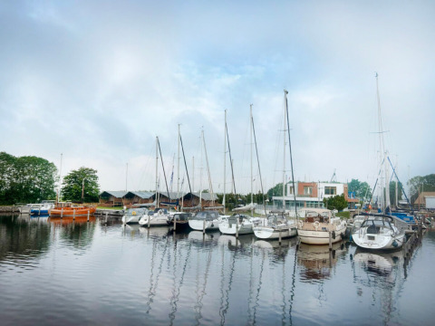 Boote festgemacht am Hafen von Minicamping Marina Warns in Friesland, Niederlande – ruhiger Ferienort.