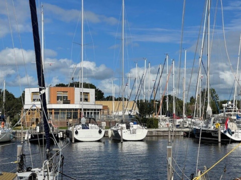 Både og lystbådehavn ved Minicamping Marina Warns i Friesland, Holland, under en blå skyet himmel.