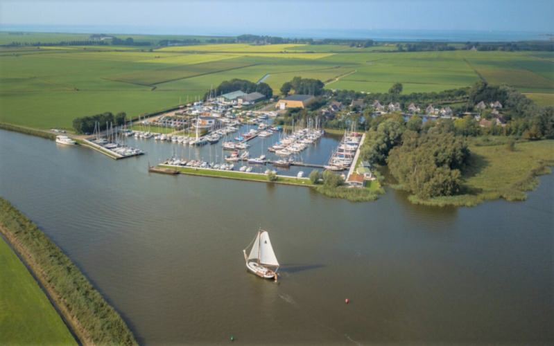 Aerial view of Minicamping Marina Warns holiday park and marina in Friesland, Netherlands, surrounded by fields.
