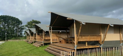 Rangée de tentes safari sur terrasses en bois à Minicamping Marina Warns, parc de vacances en Frise, Pays-Bas.