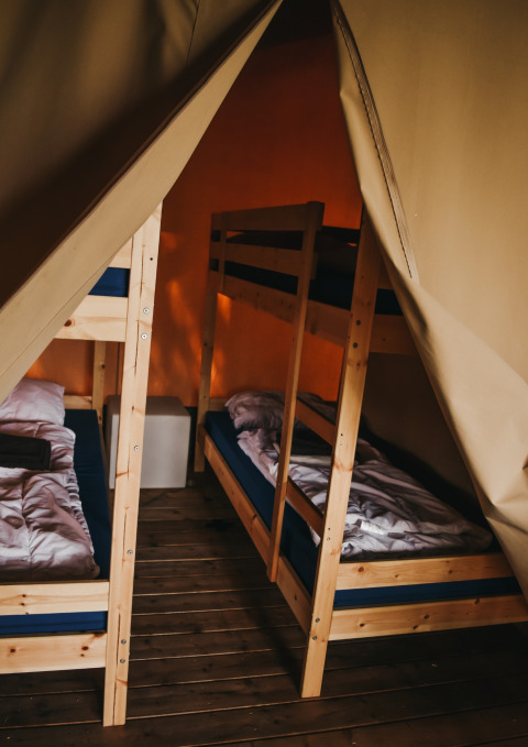 Innenansicht des Safari Tent Valley auf Camping Lucherino in Italien mit Holz-Etagenbetten und Holzboden.