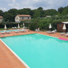 Outdoor swimming pool with sun loungers and umbrellas at Camping Monti del Sole holiday park in Umbria, Italy.