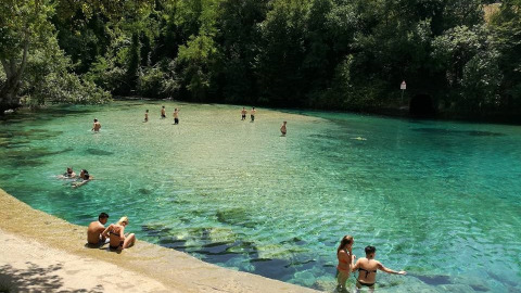 Personas nadan y se relajan en las aguas cristalinas de un estanque natural cerca de Narni, Umbría, Italia.