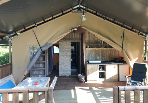 Interior de tienda glamping con cocina y comedor en Camping Monti del Sole, parque vacacional en Umbría, Italia.