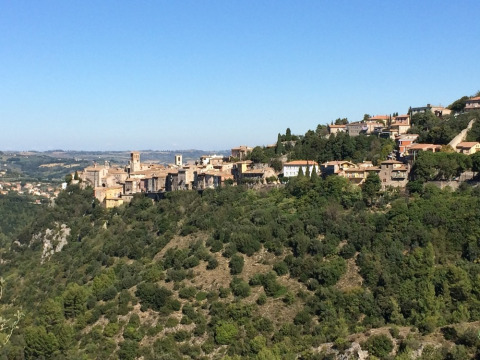 Vista panorámica de Narni, una ciudad histórica de Umbría, Italia, rodeada de colinas verdes y cielo azul.