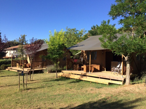 Tentes glamping avec terrasses en bois au Camping Monti del Sole, parc de vacances en Ombrie, Italie, ensoleillé.