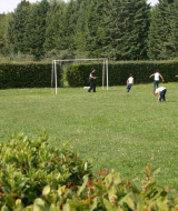Des enfants jouent au football sur une pelouse entourée d’arbres à Camping Monti del Sole en Ombrie, Italie.