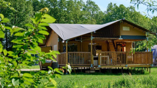 Safaritent Ranger Lodge bij Recreatiepark Den Blanken in Nederland, omringd door groene natuur.