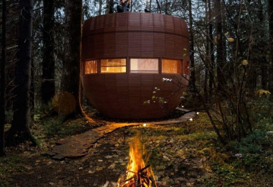 Avondbeeld van The Nutshell tiny house met vuurkorf en sauna in het bos bij Den Blanken, Nederland.