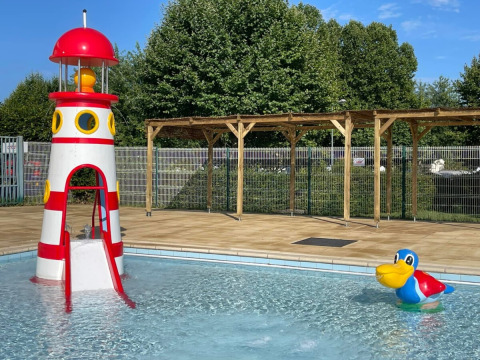 Piscina infantil con tobogán de faro y flotador de pato colorido en Camping de Thoissey, Auvergne-Rhône-Alpes.