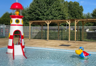 Kinderzwembad met vuurtorenglijbaan en kleurrijke eend bij Camping de Thoissey in Auvergne-Rhône-Alpes.