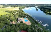 Vue aérienne du Camping de Thoissey en Auvergne-Rhône-Alpes avec piscine, port de plaisance et arbres au bord du fleuve.