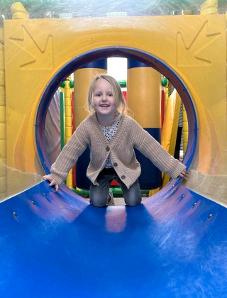 A child plays inside a colorful tunnel at the indoor playground of Recreation Park Den Blanken, Gelderland.