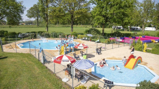 Zona de piscina exterior para familias en Recreation Park Den Blanken, con toboganes y ambiente relajado.
