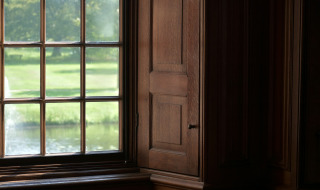 Ventana con marco de madera y vista al césped y estanque, tomada cerca de Neede, Gelderland, Países Bajos.