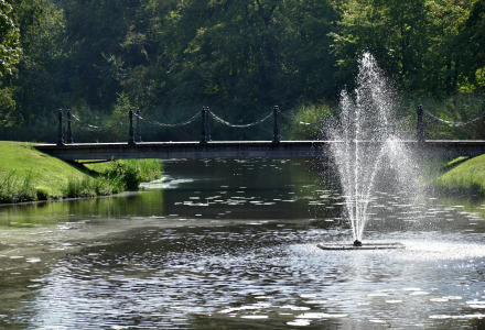 Un estanque pintoresco con fuente y puente en los alrededores de Neede, Gelderland, Países Bajos, rodeado de naturaleza.