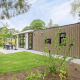 Moderne lodge ved navn Module Special Wellness med træbeklædning, terrasse og grønne omgivelser.