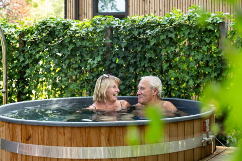 Ældre par nyder wellness i udendørs boblebad ved Module Special Wellness på Bospark Ede i Holland.
