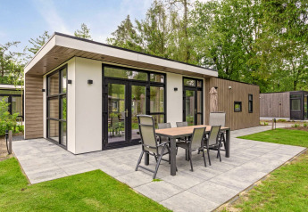 Lodge moderno con amplia terraza y comedor exterior en Bospark Ede, rodeado de naturaleza en los Países Bajos.