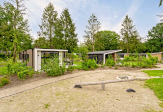 Uitzicht op Module Special Wellness lodge met hottub in Bospark Ede, Nederland, omgeven door groen.