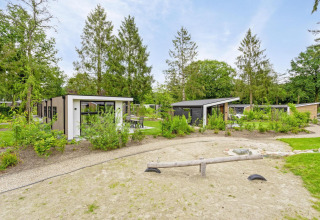Uitzicht op Module Special Wellness lodge met hottub in Bospark Ede, Nederland, omgeven door groen.
