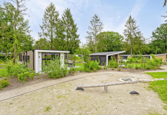 Udsigt over Module Special Wellness lodge med spabad i Bospark Ede, Nederlandene, omgivet af skov.