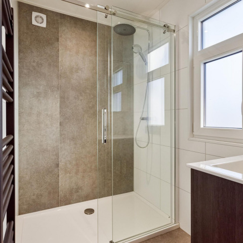 Moderne Dusche mit Glaswand und Regenduschkopf in einer Lodge im Bospark Ede, Niederlande.