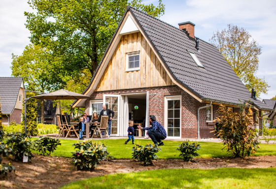 Famiglia si gode una giornata soleggiata davanti a Wellness Lodge XL a Hof van Salland, Paesi Bassi.
