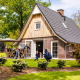 Familie nyder tid sammen udenfor Wellness Lodge XL på Hof van Salland, Nederlandene, med have og terrasse.