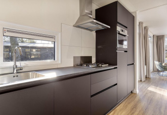 Moderne Küchenzeile in der Lodge Module Special Wellness mit Glasfenster im Bospark Ede, Niederlande.